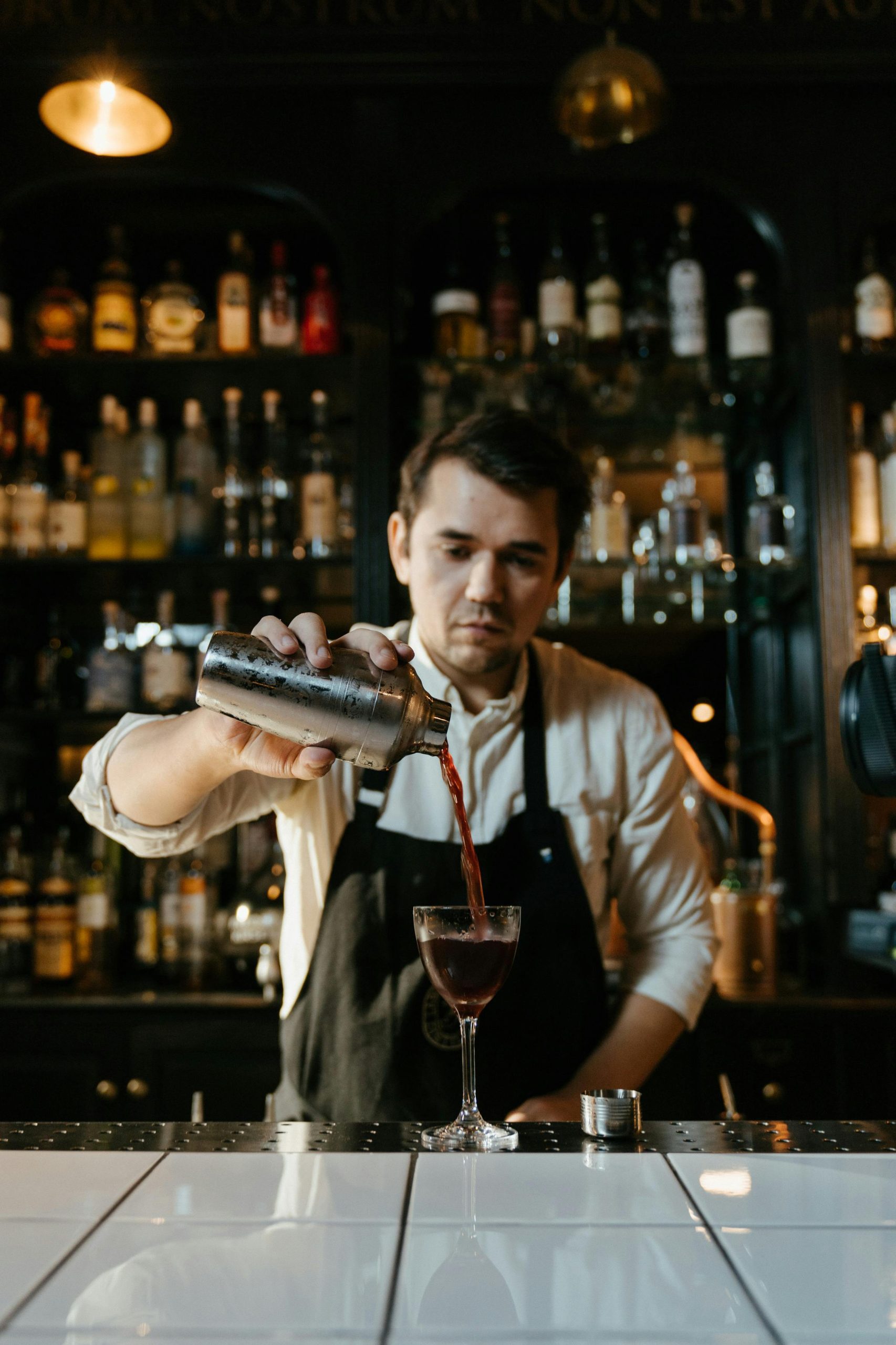 Man pouting a drink in a bar