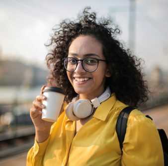 Self portrait of woman in a yellow jacket with a cup